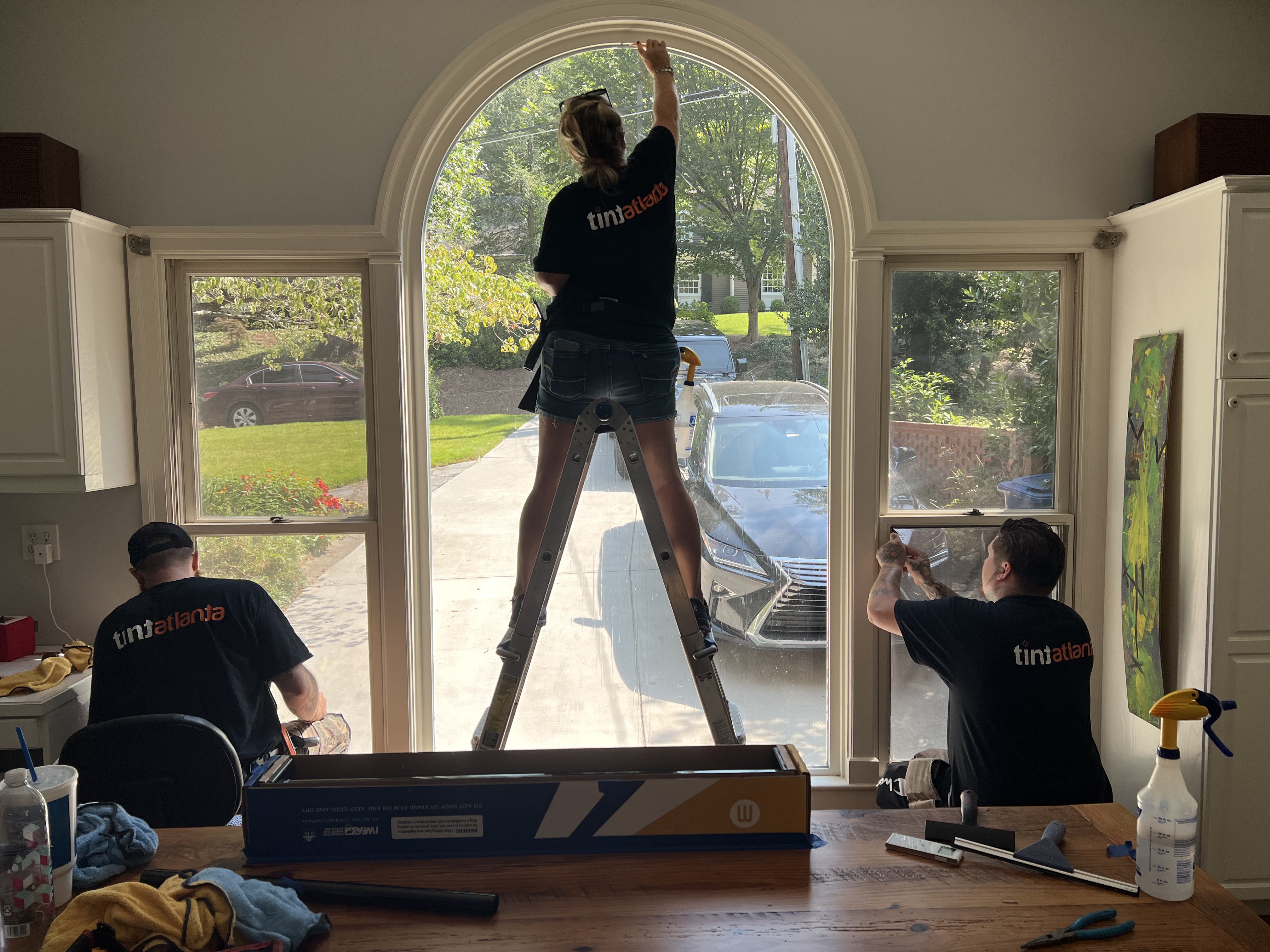 Tint Atlanta team installing residential window film